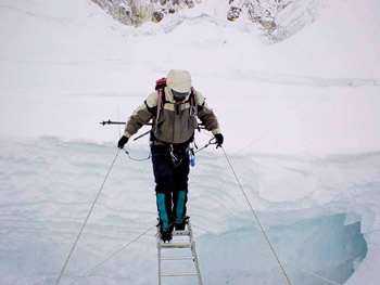 Nawang carefully crossing a huge crevasse in the deadly Khumbu Icefall.